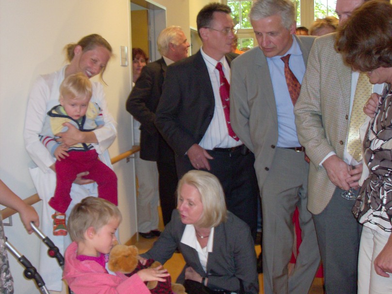 Manfred Kolbe beim Rundgang durch die Kinderklinik mit Sozialministerin Claus (kniend)